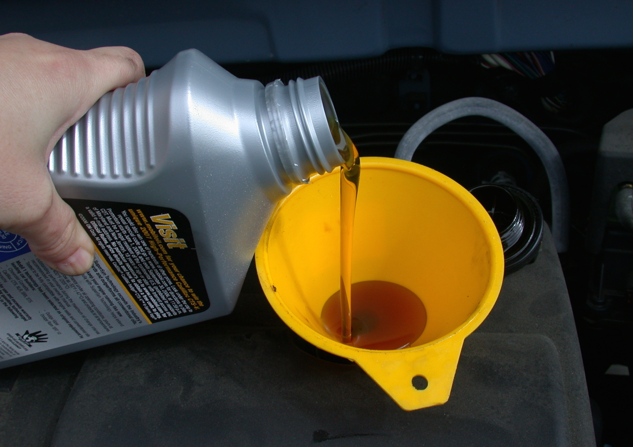 Motor_oil_refill_with_funnel