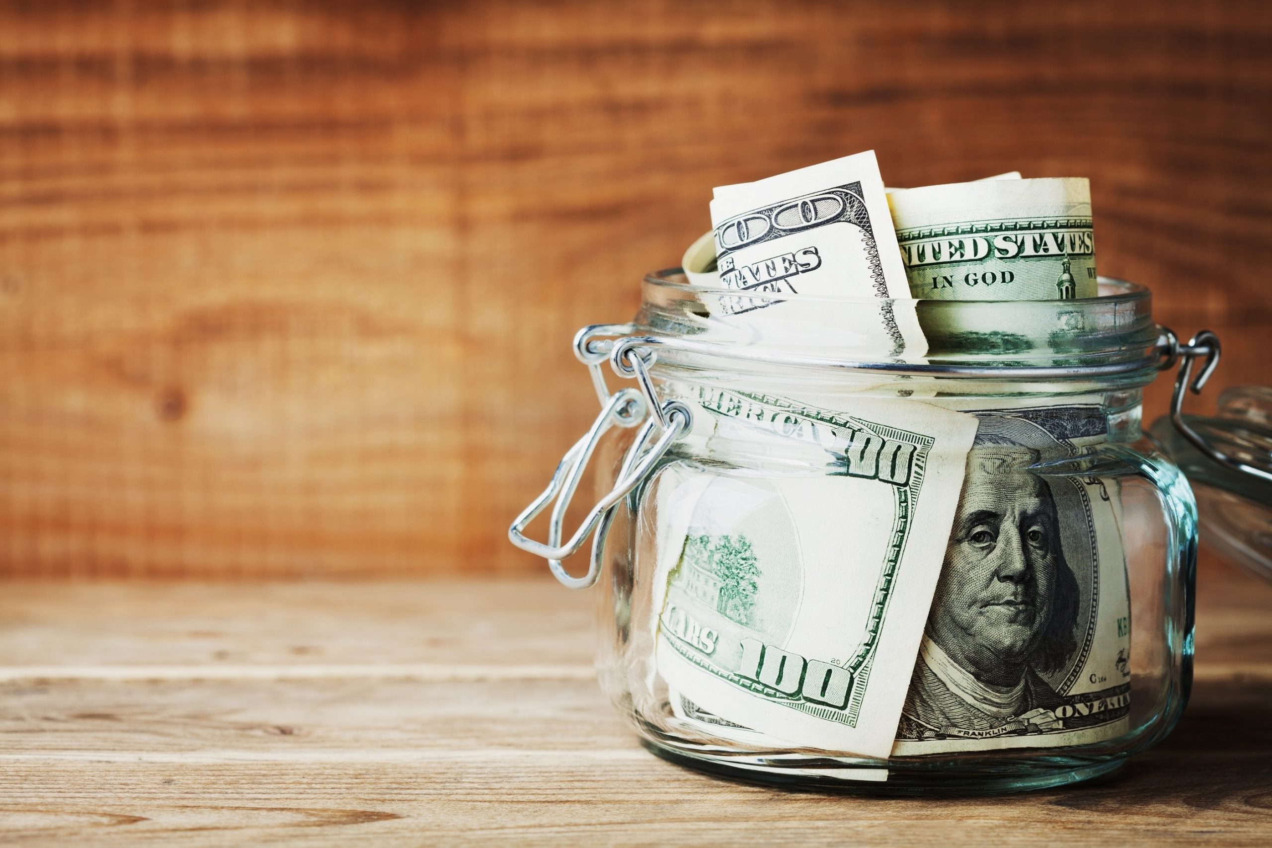 hundred dollar bills in a jar